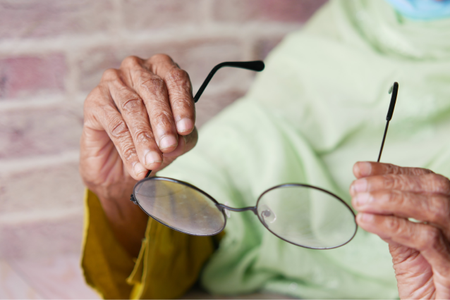 Older person holding glasses